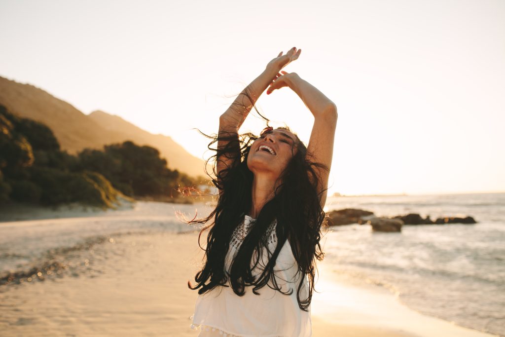 Beautiful woman enjoying a summer day on the beach. Caucasian female having a great time on her vacation.